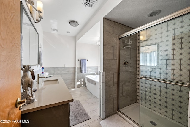 bathroom featuring vanity, tile walls, and shower with separate bathtub