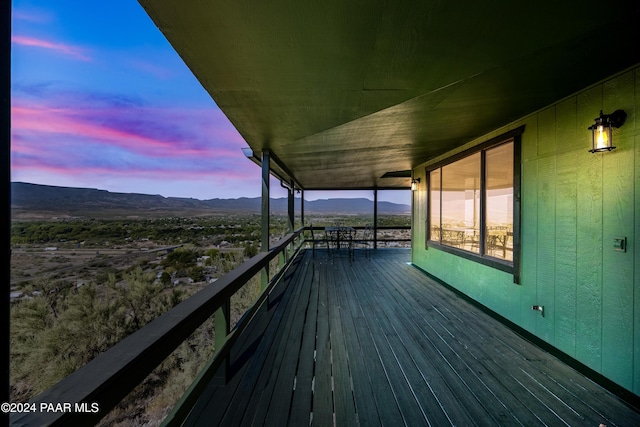 deck at dusk featuring a mountain view