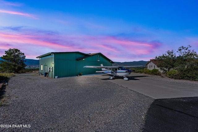 property exterior at dusk featuring a mountain view