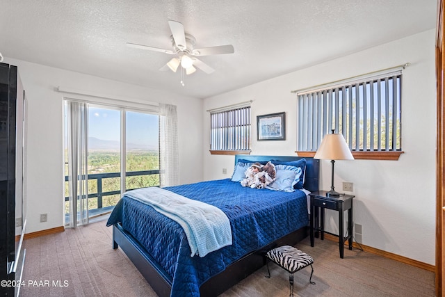 carpeted bedroom with ceiling fan and a textured ceiling