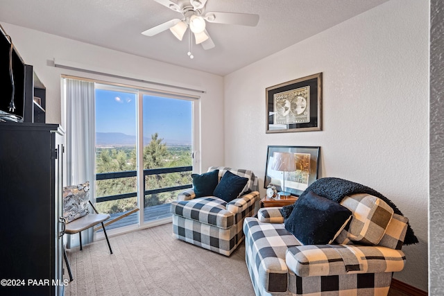 sitting room featuring ceiling fan and light colored carpet