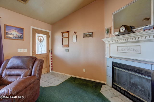 tiled foyer entrance featuring a tile fireplace and vaulted ceiling