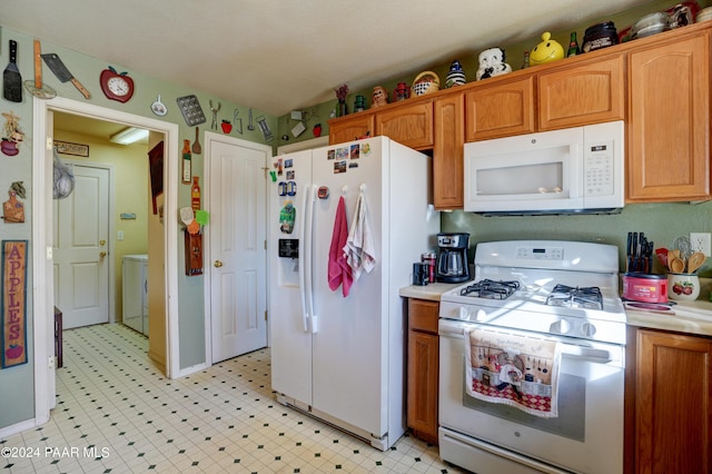 kitchen with washer and dryer and white appliances