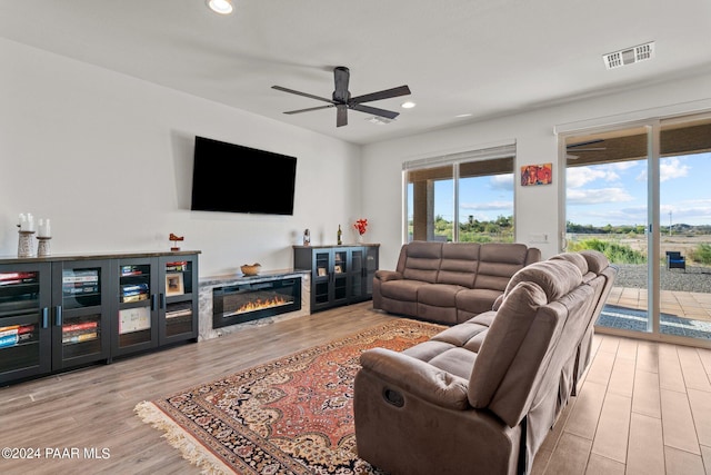 living room featuring ceiling fan and light hardwood / wood-style flooring