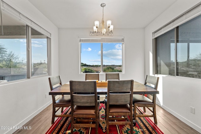 dining area with wood-type flooring and an inviting chandelier