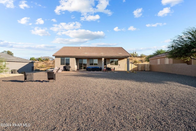 rear view of house with a jacuzzi