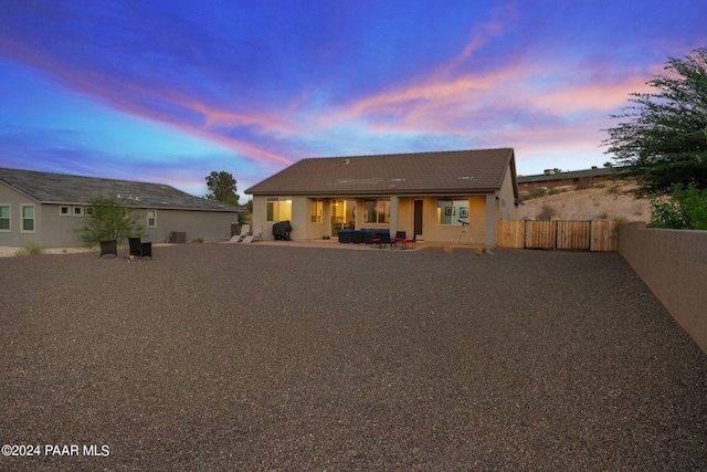 back house at dusk featuring outdoor lounge area