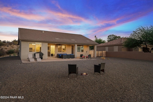 back house at dusk featuring a patio area and an outdoor hangout area