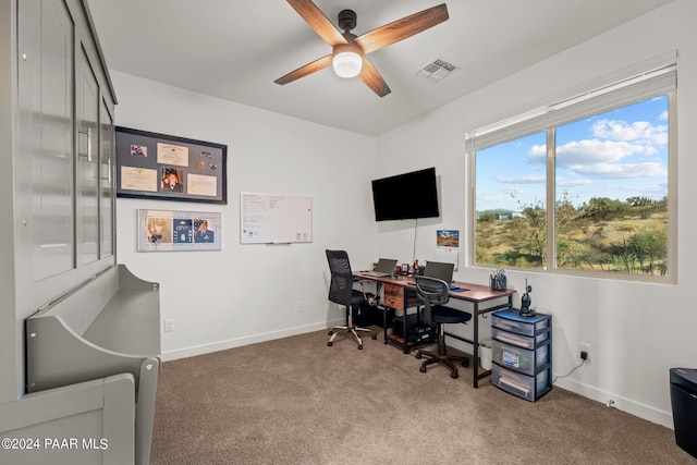 carpeted home office featuring ceiling fan