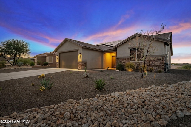 ranch-style home with a garage and solar panels