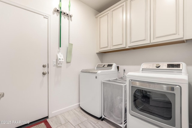 laundry area featuring baseboards, cabinet space, and washing machine and dryer