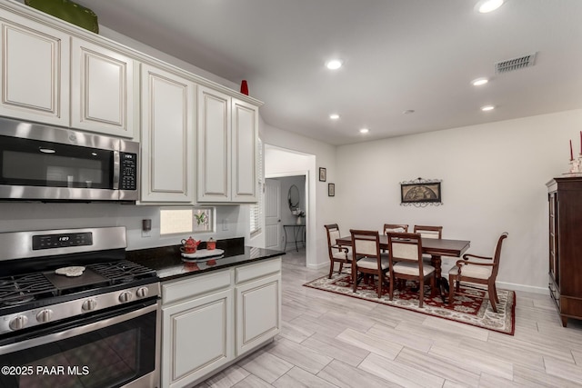 kitchen with visible vents, wood tiled floor, recessed lighting, stainless steel appliances, and dark countertops