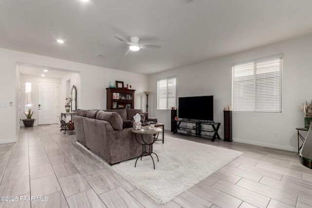 living room featuring visible vents, wood finish floors, baseboards, and ceiling fan