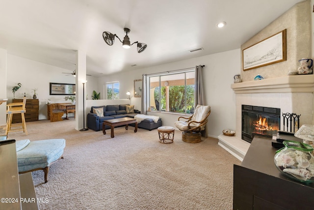 living room with ceiling fan, light colored carpet, and a fireplace