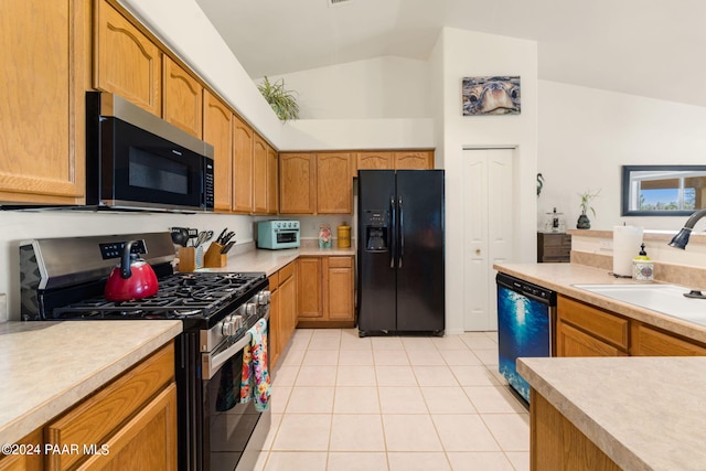 kitchen with sink, vaulted ceiling, black appliances, and light tile patterned flooring