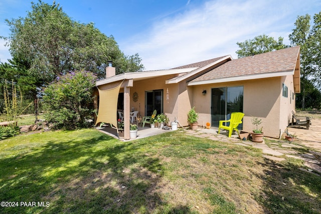 rear view of house with a patio area and a lawn