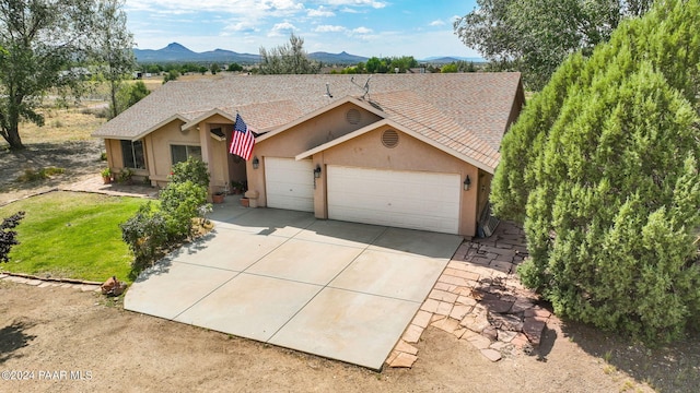 ranch-style house with a garage and a mountain view