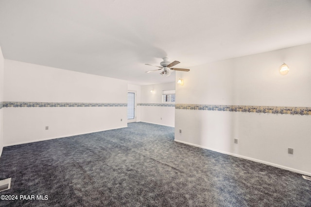 empty room with dark carpet and ceiling fan