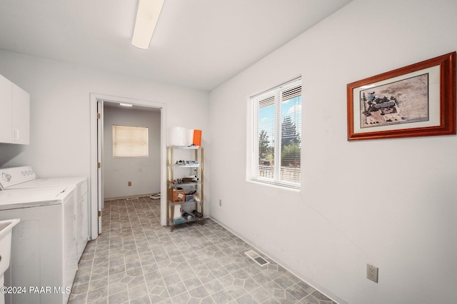 washroom with cabinets and washing machine and dryer