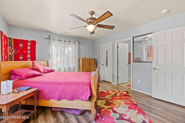 bedroom with hardwood / wood-style floors, a textured ceiling, and ceiling fan