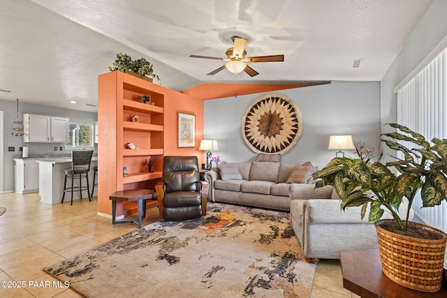 tiled living room with a textured ceiling, vaulted ceiling, and ceiling fan