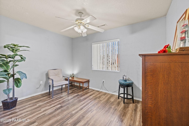 sitting room featuring hardwood / wood-style flooring, a textured ceiling, and ceiling fan