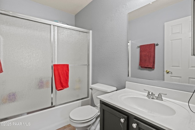 full bathroom featuring vanity, shower / bath combination with glass door, and toilet