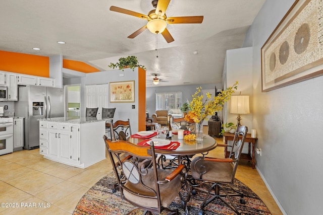 dining room featuring light tile patterned flooring, ceiling fan, and vaulted ceiling