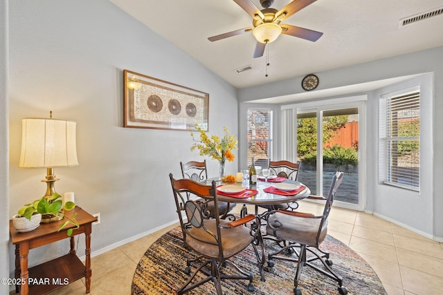 tiled dining space featuring lofted ceiling and ceiling fan