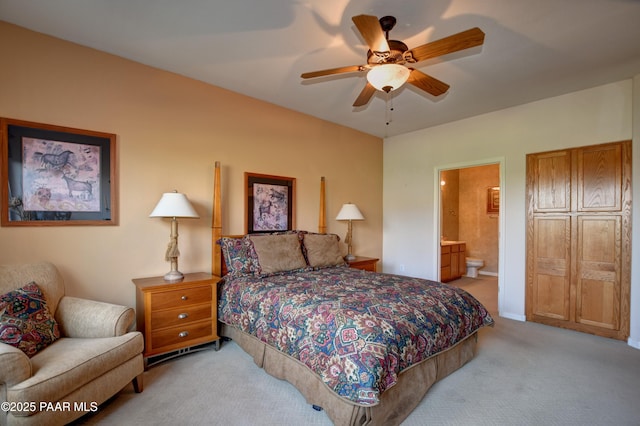 bedroom with ceiling fan, light carpet, and ensuite bath
