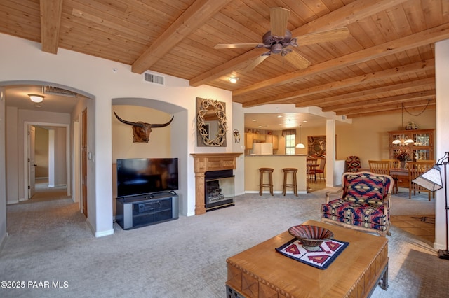 living area featuring a ceiling fan, arched walkways, carpet, and wood ceiling