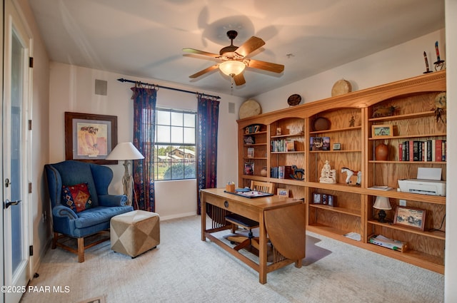 home office featuring a ceiling fan, baseboards, and light carpet