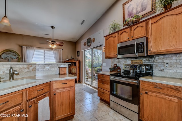 5461 N Bremont Way, Prescott Valley, AZ 86314 - kitchen with stainless steel appliances, a sink, vaulted ceiling, decorative backsplash, and brown cabinetry