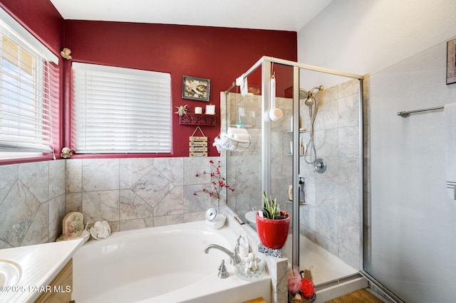 bathroom with a stall shower, vanity, and a bath