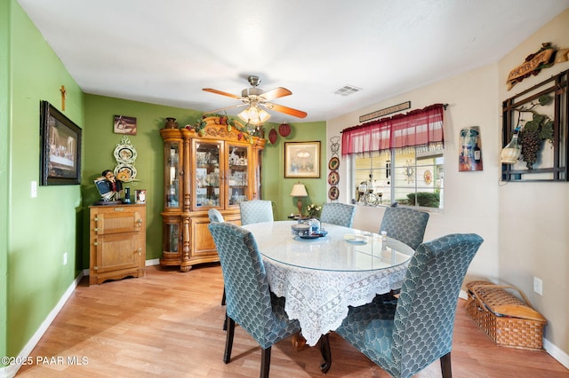 dining room with baseboards, visible vents, and wood finished floors