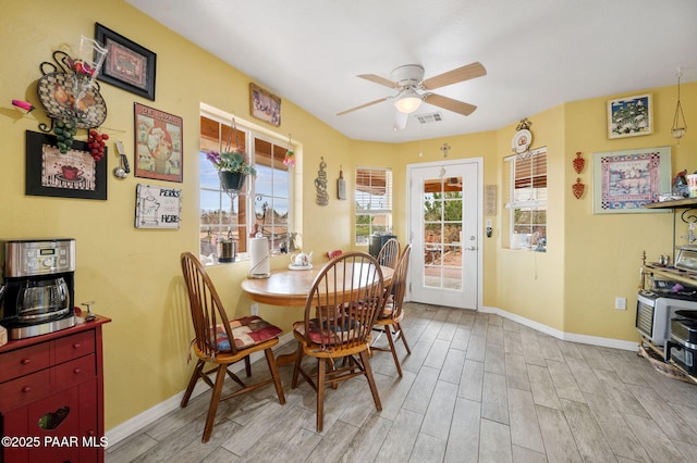 dining space featuring light wood-type flooring, visible vents, plenty of natural light, and baseboards