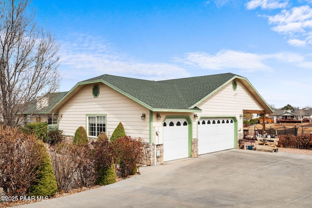 view of front of house with stone siding, concrete driveway, roof with shingles, and an attached garage