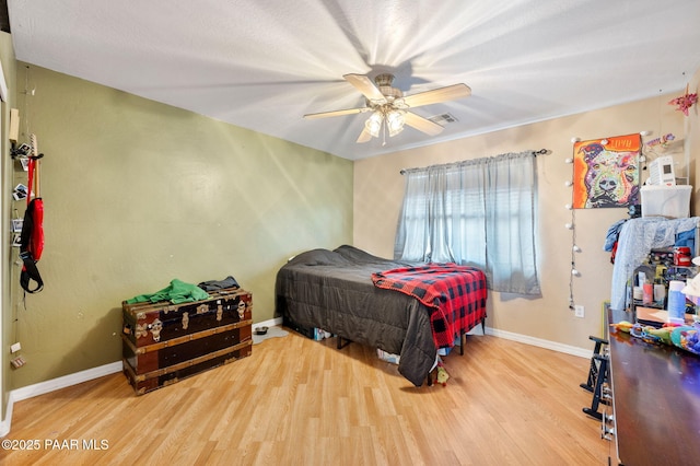 bedroom featuring visible vents, wood finished floors, a ceiling fan, and baseboards