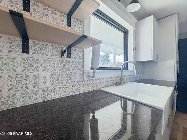 kitchen with dark stone counters, decorative backsplash, and white cabinets