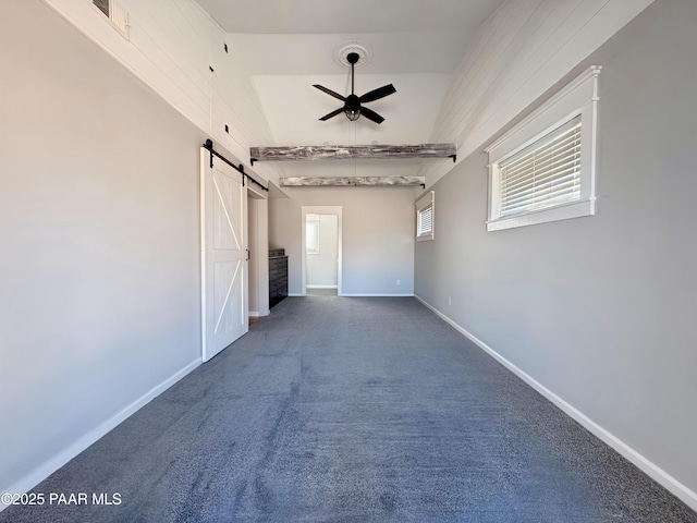 spare room featuring a barn door, carpet, and ceiling fan