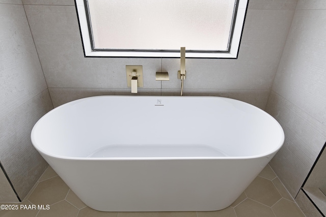 full bathroom with a soaking tub, a healthy amount of sunlight, and tile patterned flooring