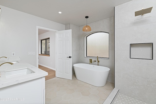 full bathroom with double vanity, a freestanding tub, a sink, a walk in shower, and tile patterned floors