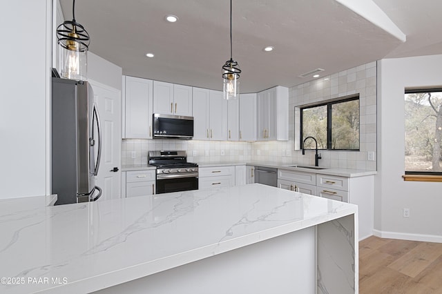 kitchen with tasteful backsplash, visible vents, appliances with stainless steel finishes, and a sink