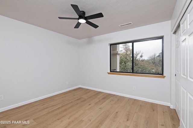 unfurnished bedroom with light wood-style flooring, baseboards, visible vents, and a closet