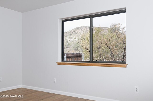 unfurnished room featuring baseboards and wood finished floors