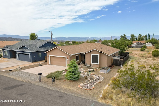 single story home featuring a mountain view and a garage