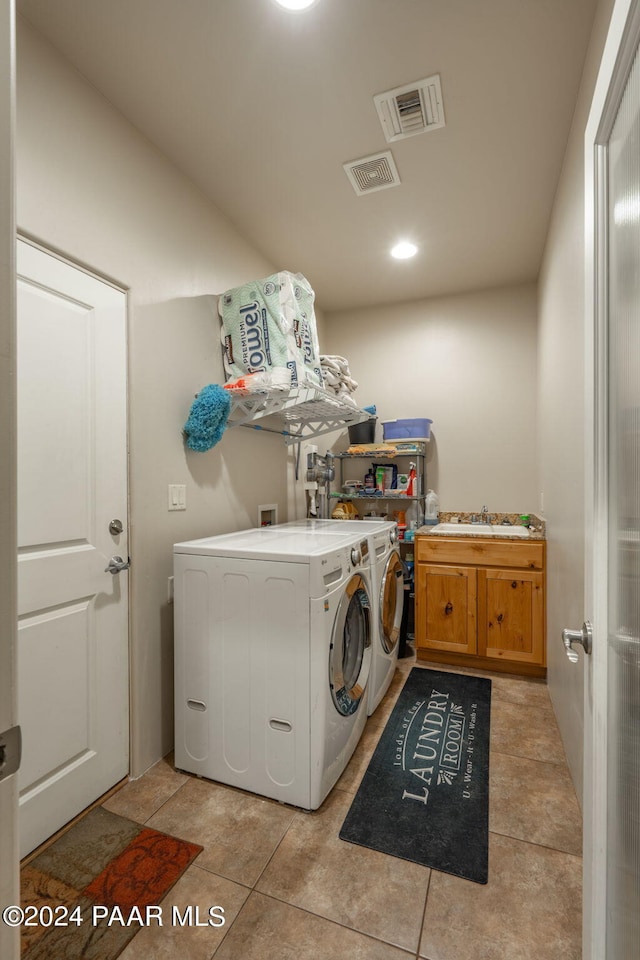 clothes washing area featuring separate washer and dryer, sink, light tile patterned flooring, and cabinets