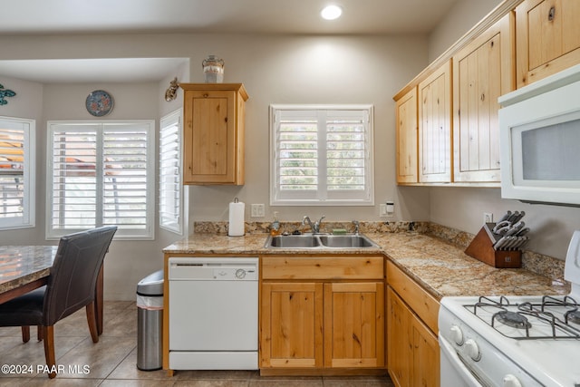 kitchen with light brown cabinetry, white appliances, sink, and light tile patterned floors