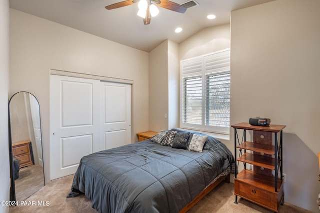 bedroom with light carpet, a closet, lofted ceiling, and ceiling fan