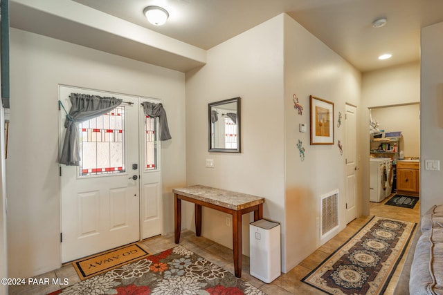 tiled entrance foyer with a healthy amount of sunlight and independent washer and dryer